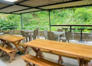 un gruppo di tavoli e sedie in legno su un patio di FINCA CAMPESTRE EL PORVENIR a Quimbaya