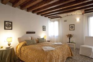 a bedroom with a large bed in a room with wooden ceilings at Cà dell'Ambasciatore in Venice