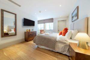 um quarto com uma cama grande e um espelho em Mayfair - Exclusive 4 Bedroom Apartment em Londres