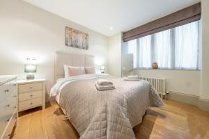 um quarto com uma cama grande e uma janela em Mayfair - Exclusive 4 Bedroom Apartment em Londres
