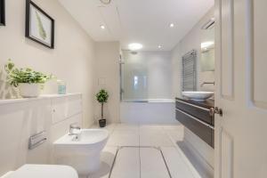 uma casa de banho com um lavatório, um WC e uma banheira em Mayfair - Exclusive 4 Bedroom Apartment em Londres