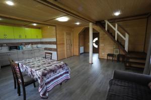 a room with a table and a kitchen and a staircase at Шпінь 3 in Vorokhta