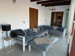 Belvilla by OYO Castillo El Toro في فينيسترات: غرفة معيشة مع أريكة زرقاء وطاولة