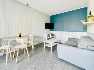 a living room with a bed and a table and a couch at T2 au rez de chaussée dans propriété privée, au bord de l'eau à 15 minutes de Nancy in Toul