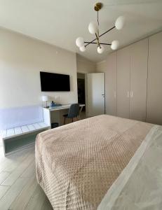 a bedroom with a bed and a desk and a tv at NOVIMO Comfort Apartment - with elevator & secure parking in Terrasini