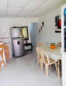 a kitchen with a table and a stainless steel refrigerator at Cabañas Ypaos in Coveñas