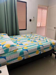 a bed with a colorful comforter in a bedroom at Cabañas Ypaos in Coveñas +5 photos