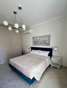 a bedroom with a large bed and a chandelier at NOVIMO Comfort Apartment - with elevator & secure parking in Terrasini
