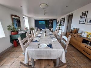a long dining room with a long table and chairs at Heir Island House in Skibbereen
