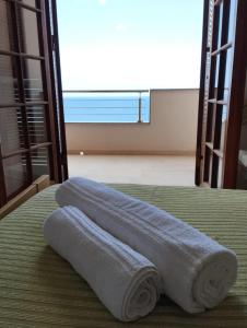 une paire de serviettes assises au-dessus d'un lit dans l'établissement Brezza Marina IUN R6124, à Castelsardo