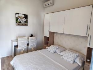 Schlafzimmer mit einem Bett mit weißen Schränken in der Unterkunft Apartmani Seka in Vodice