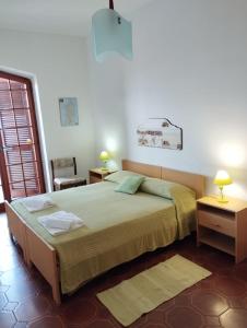 1 dormitorio con 1 cama grande y 1 silla en Brezza Marina IUN R6124, en Castelsardo