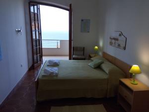 a bedroom with a bed with a view of the ocean at Brezza Marina IUN R6124 in Castelsardo