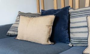 - un ensemble d'oreillers assis sur un canapé bleu dans l'établissement Aurora Suite à Champel avec terrasse, à Genève