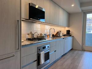 洛杉矶Calypso- Hollywood Apartment with Pool, Gym FREE parking的厨房配有水槽和炉灶。