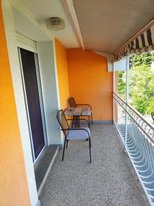 einen Stuhl auf dem Balkon eines Hauses in der Unterkunft Apartmani Seka in Vodice