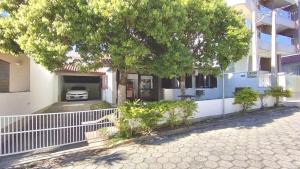 a tree in front of a house with a garage at A55 - Casa centro de Bombinhas in Bombinhas