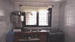 a small kitchen with a sink and a window at A55 - Casa centro de Bombinhas in Bombinhas