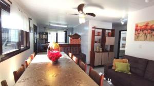 a dining room with a long table and chairs at A55 - Casa centro de Bombinhas in Bombinhas +14 photos