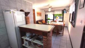 a kitchen with a refrigerator and a table and a dining room at A55 - Casa centro de Bombinhas in Bombinhas