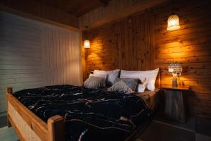 a bedroom with a bed with a wooden wall at Soho house in Jibhi