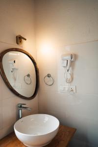 a bathroom with a white sink and a mirror at Soho house in Jibhi