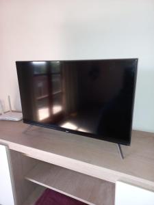 TV de pantalla plana grande en la parte superior de una mesa en Departamento Céntrico en Posadas