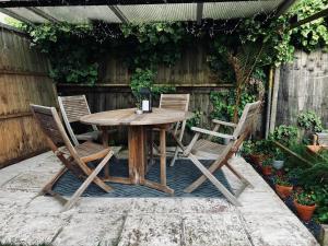 a wooden table and chairs in a garden at The Smiling Frog in Portchester
