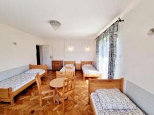 a room with four beds and a table and chairs at Hostel Rumiankowy Airport Hostel in Wrocław