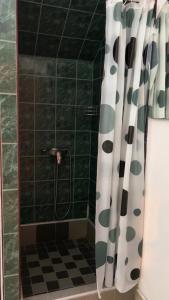 een badkamer met een douche met een zwart-wit douchegordijn bij Motel Kantić in Tuzla