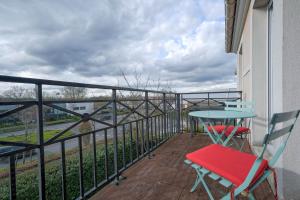 einen Balkon mit einem Tisch, Stühlen und einem Tisch in der Unterkunft Apart' Minnie - Disneyland Paris - 3 Bedrooms - Parking privé in Magny-le-Hongre