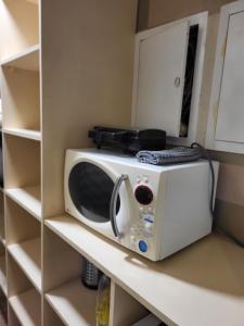 a microwave sitting on a shelf in a kitchen at Classic Apartment in Jūrmala