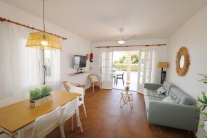 uma sala de estar com uma mesa e um sofá em Villa Las Marinas - 2 Encantadora Villa con piscina a 5 min de la playa em Arenal d'en Castell