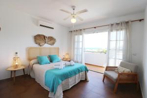 a bedroom with a bed and a chair and a window at Villa Las Marinas - 2 Encantadora Villa con piscina a 5 min de la playa in Arenal d'en Castell +13 photos