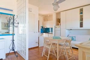 a kitchen and dining room with a table and chairs at By the sea with amazing view in Capo Coda Cavallo