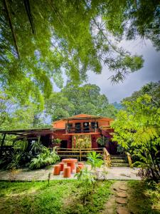 an orange house in the middle of a garden at Casa del Pozo Azul in Minca