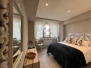 a small bedroom with a bed and a window at EL MIRADOR DEL CENTRO in Gijón