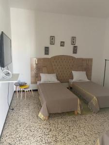 a living room with two beds and a tv at Studio CoCoti in Tataouine