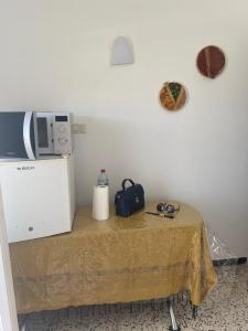 a table with a microwave on top of it at Studio CoCoti in Tataouine