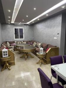 a living room with couches and tables and chairs at Location appartement Alhoceima in Al Hoceïma