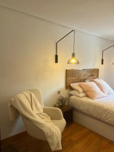un dormitorio con una cama y una silla en APARTAMENTO TURÍSTICO SAN NICOLAS, en Avilés 27 fotos más