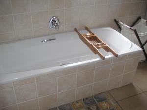 una bañera con un estante en el lateral. en WatersideLiving MS11, en Jeffreys Bay 16 fotos más