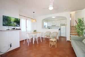 uma sala de estar e cozinha com mesa e cadeiras em Villa LAS MARINAS - 4, con piscina privada y a 5 minutos de la playa em Arenal d'en Castell