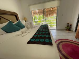 a bedroom with a large white bed with a window at Home's Jungle Puerto Morelos Cancun 20 Minutes from the Airport in Cancún
