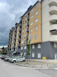a parking lot with cars parked in front of a building at Bela in Kumanovo