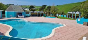 a large swimming pool in a yard with a house at Coastal Retreat Newquay NB91 in Newquay