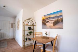 a dining room with a table and a painting on the wall at FEWO Schule Altes Land in Jork