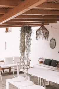 Casa Om في Dosríus: غرفة معيشة مع طاولات وكراسي بيضاء