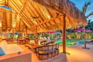 a resort with a pool and a straw umbrella at Bungalow LUXURY cerca a la Playa Zihuatanejo Mexico in Ixtapa