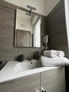 uma casa de banho com um lavatório branco e um espelho. em SLEEP & FLY Bergamo Centro em Bérgamo